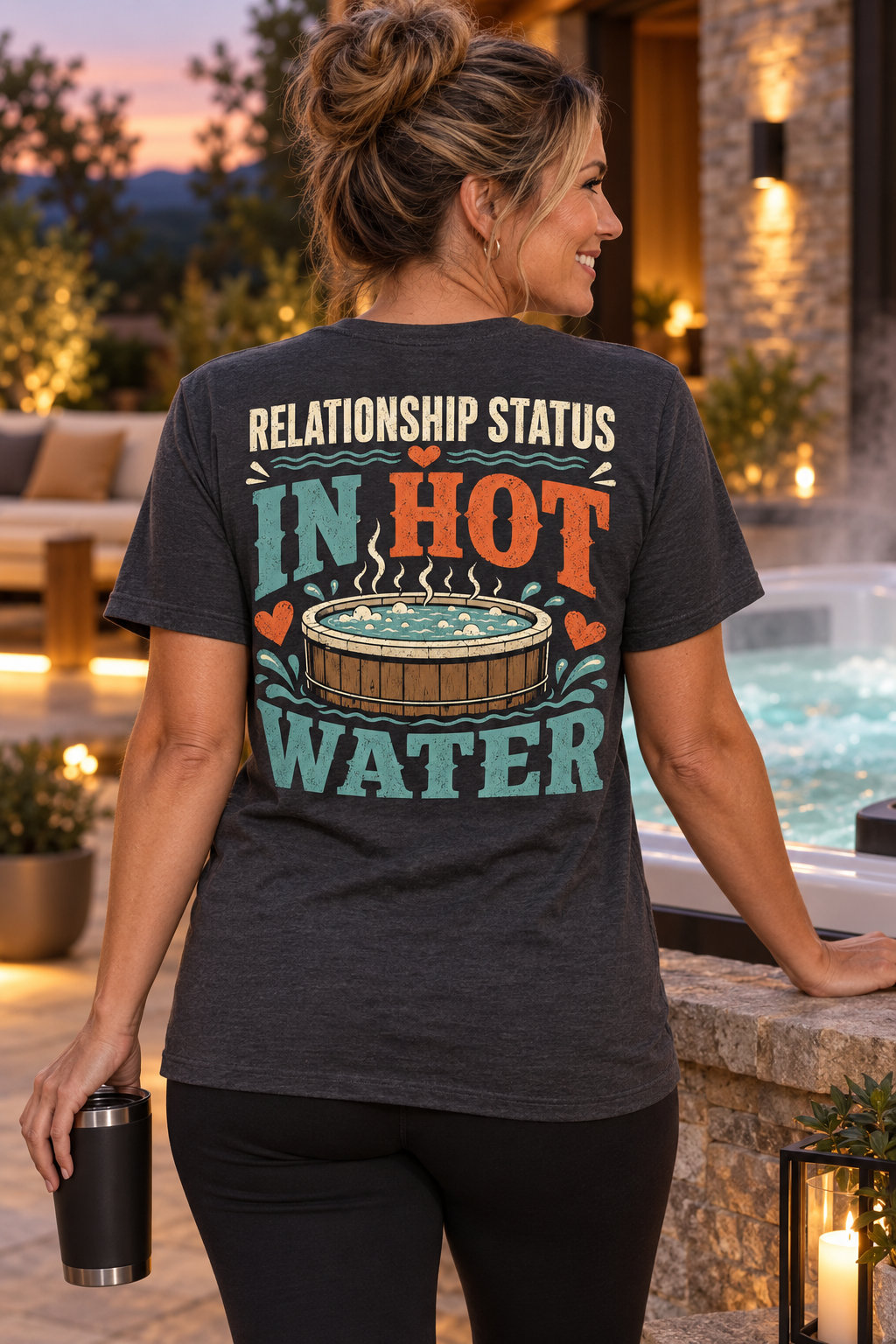 Model wearing Relationship Status: In Hot Water hot tub T-shirt beside a luxury spa